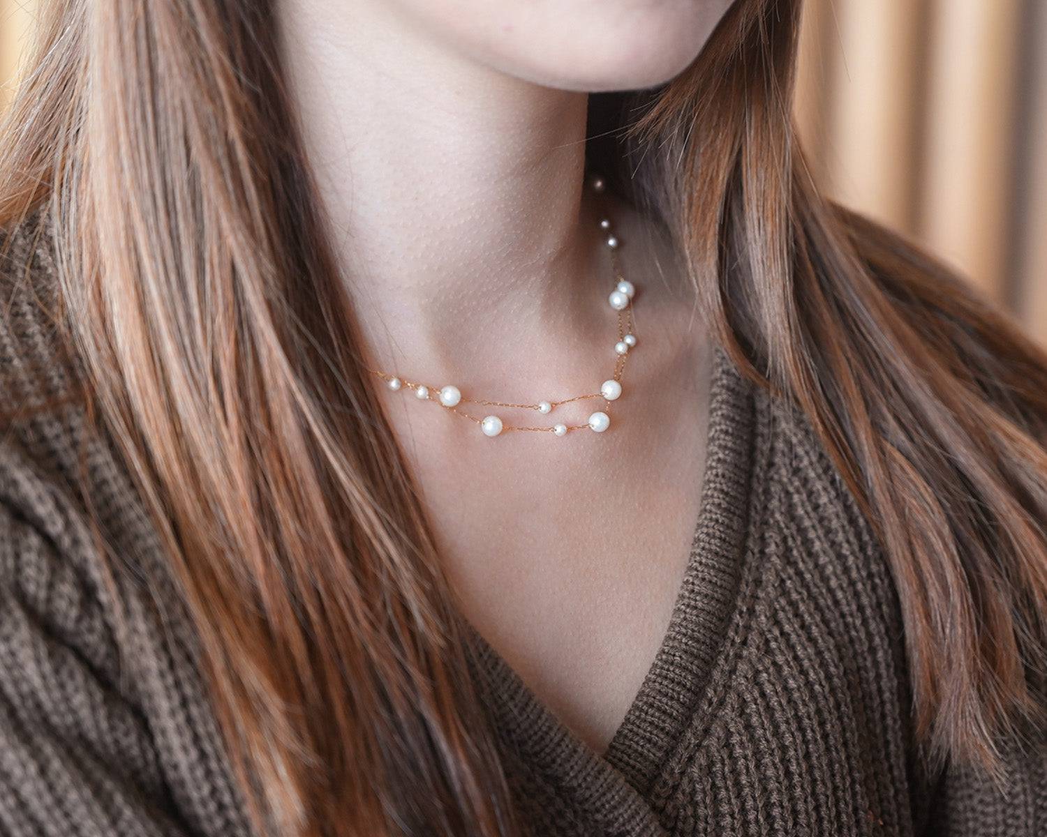 A woman wearing brown sweater with the Double Layer Pearl Cascade Necklace